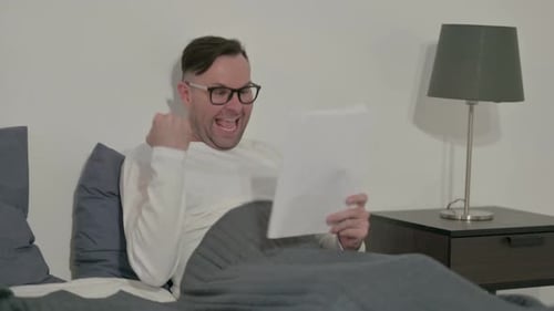 Man Reading Good News in Bed