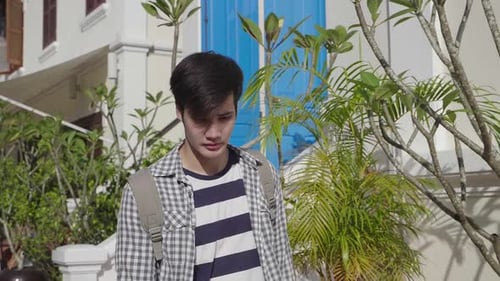 Young Adult Standing Near Urban Building on Bright Day