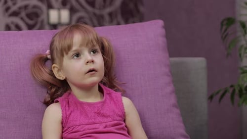Kleines Kind sitzt beim Fernsehen auf der Couch. Kid Girl Fernsehen schauen