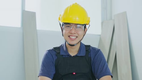 Portrait of Asian Craftsman or Carpenter builder man look at camera while work to renovate house.
