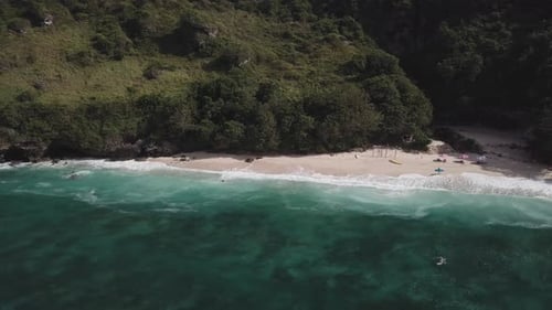 Luftaufnahme des tropischen Strandes mit azurblauem Wasser und schäumenden Meereswellen