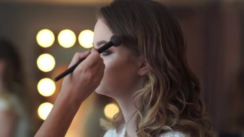 Girl Makeup Artist Applies Face Powder