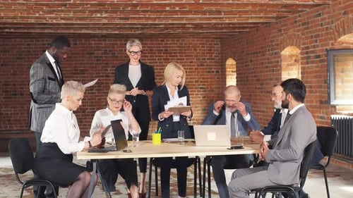 Verschiedene alte Büroangestellte versammeln sich und diskutieren über Online-Projekt-Lachen