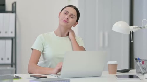 Young Woman Relieving Neck Pain at Desk