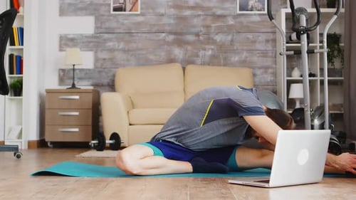 Man Stretching with Laptop in Living Room