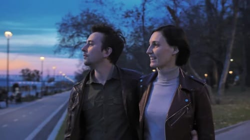 Attractive Happy Couple Embrace While Walking in the Park in the Evening