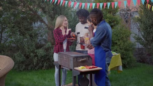 Friends Gather Around Grill at Backyard Barbecue