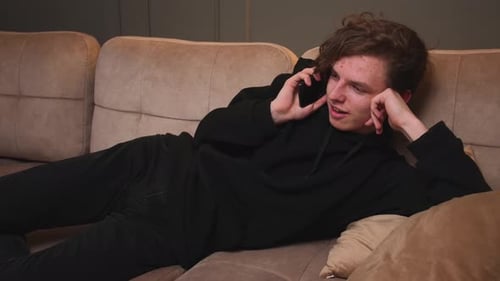 Young Adult Talking on Cellphone on Couch