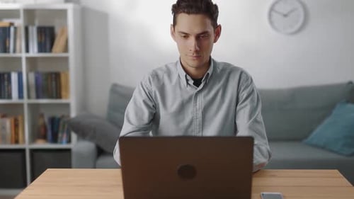 Man Using Laptop While Sitting at Table