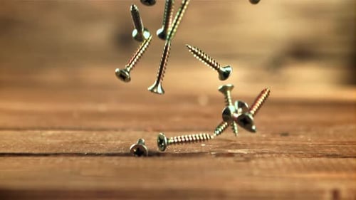 Screws Falling onto Wooden Table in Slow Motion