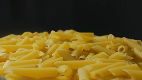 Gros plan d'un lot de pâtes Penne en rotation
