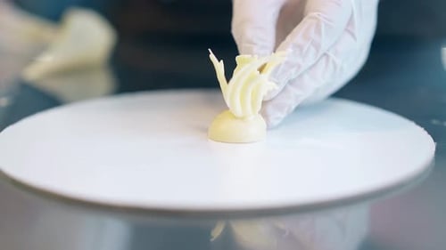 Confectioner Cooks Decorative Element From White Chocolate