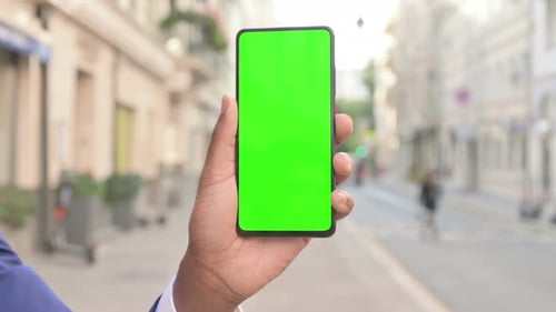 African Businessman Holding Smartphone with Green Screen