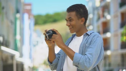 Young Adult Taking Picture with Camera in City