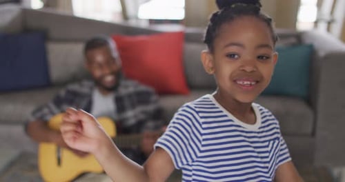 Child Dances While Father Plays Acoustic Guitar