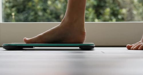 Feet Step onto Bathroom Scale for Weight Measurement