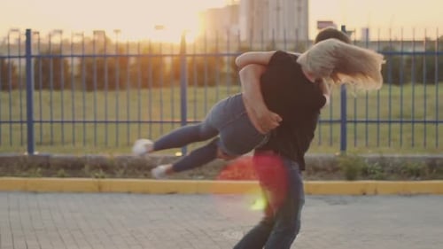 Happy Couple Embraces and Spins at Sunset