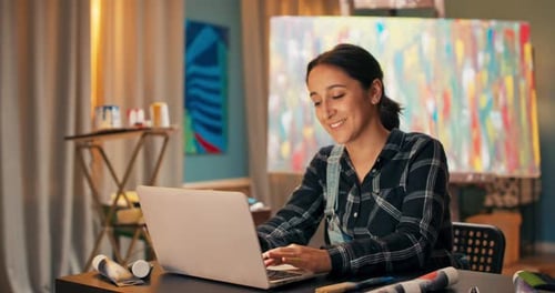 Young Woman with Smile Does Job in Painting Studio Art Storechatting to Potential Customers Gives