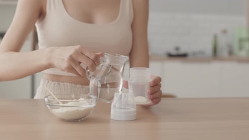 Woman Making Baby Formula in Milk Bottle