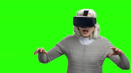 Senior Woman Experiences Virtual Reality on Green Screen