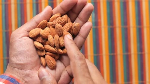 Top View of Almond Nuts on Man's Hand