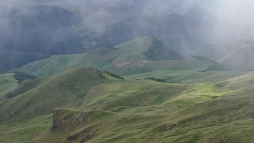 Misty rocky mountains surrounded by big thick fog.