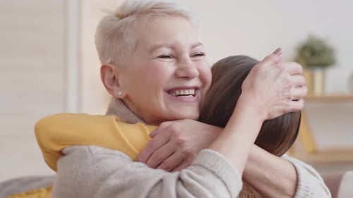 Loving Grandmother Hugging Grandchild Indoors with a Smile