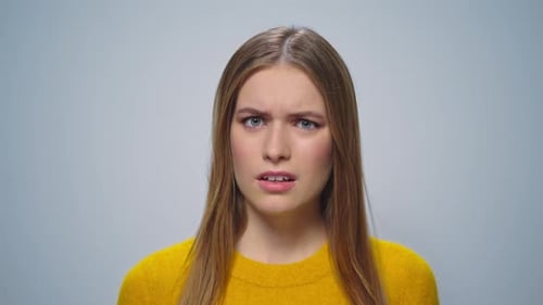 Portrait of Displeased Woman Gesturing on Grey Background in Studio