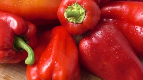 Pile of shiny red bell peppers, close up