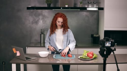 Una joven vestida de manera casual dirige un blog culinario y graba un Vídeo en Grey Kitchen