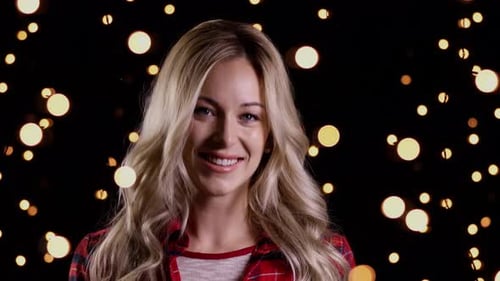 Woman Smiling with Christmas Lights Backdrop at Night