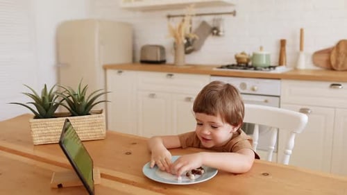 Young Boy Watching Tablet at Kitchen Table