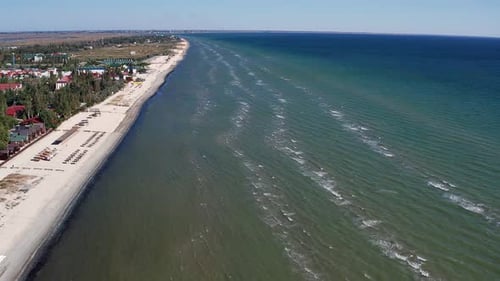 Beautiful flight in summer over the beach. People are resting near the sea.