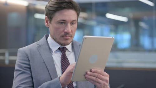 Businessman Working on Tablet in Modern Office