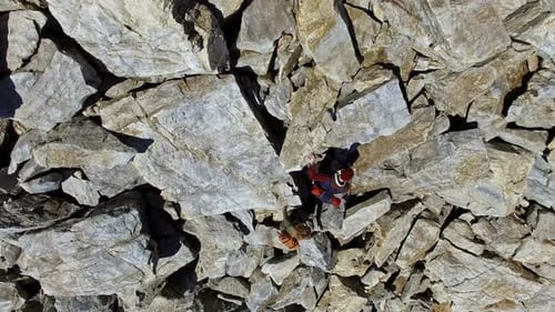 Couple Climbing Steep Rocky Mound