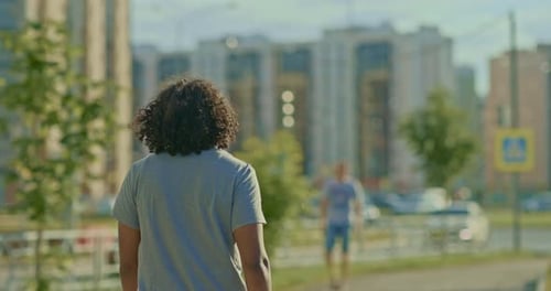 Darkskinned Man Walks Through the Summer City