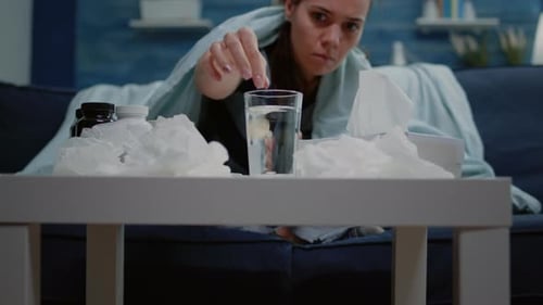 Close Up of Woman Putting Effervescent Pill in Glass of Water