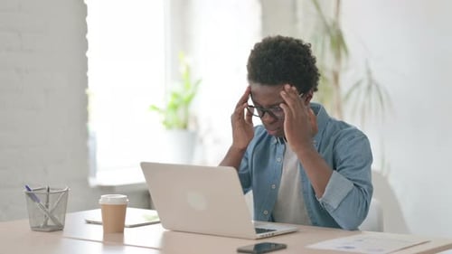 Young Adult Working on Laptop, Rubbing Temples