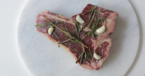 Steak frais T-Bone ou Porterhouse vieilli à sec sur planche à découper en marbre. Mariner dans de l'huile d'olive