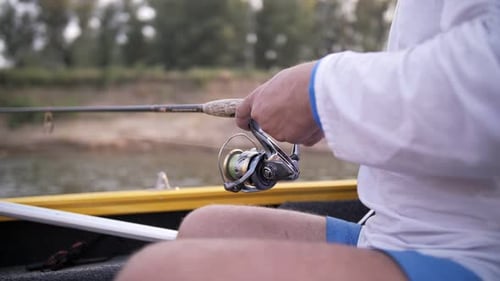ein Mann fängt Fische auf einer Angelrute von einem Boot