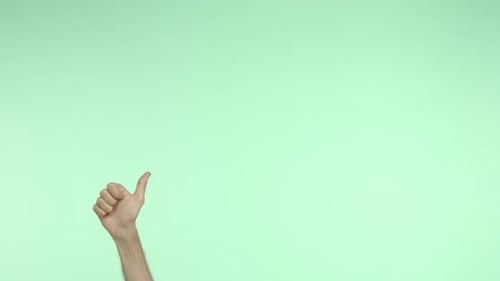 Hand Appear From Bottom of Advertisement and Showing Thumbsup Approve and Like Something Green