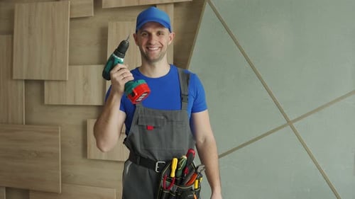 El reparador se pone de pie con un destornillador y sonríe en la habitación