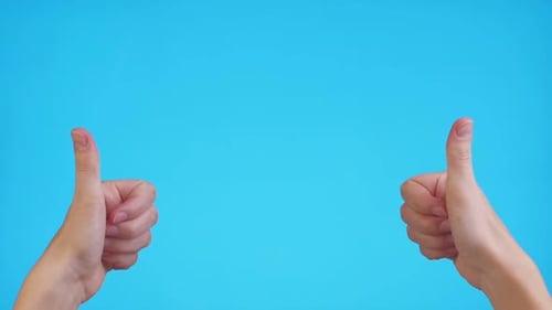 Frauenhände zeigen auf Copyspace und zeigen Daumen hoch über blauem Hintergrund