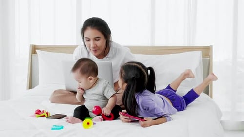 Busy single mom working from home and caring for her baby and little daughter