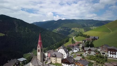 Aerial Flight Over the Bell Tower of a Church in the Dolomites