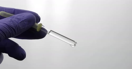 Hand in Medical Glove Drip Drop From Pipette. Close-up Video. Liquid Drop