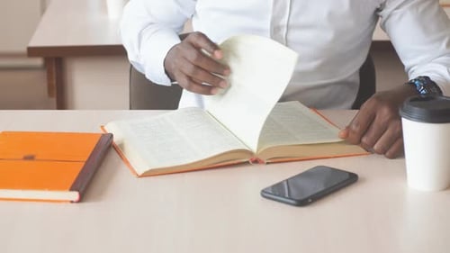 Afroamerikanischer Student bereitet sich auf Prüfungen in der Bibliothek vor.