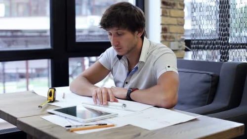 Ein Bauingenieur entwirft und bearbeitet Zeichnungen und analysiert die Struktur eines Projekts.