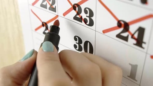 Female Hand Crosses with Red Marker the Calendar Day 30. Slow Motion Shot. Close Up