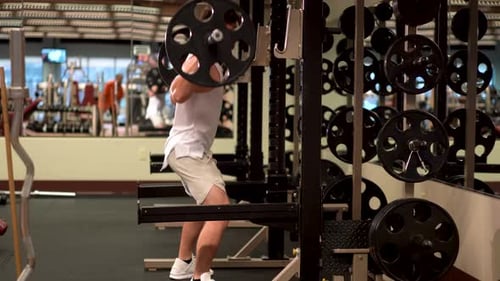Man Doing Barbell Squats in a Modern Gym